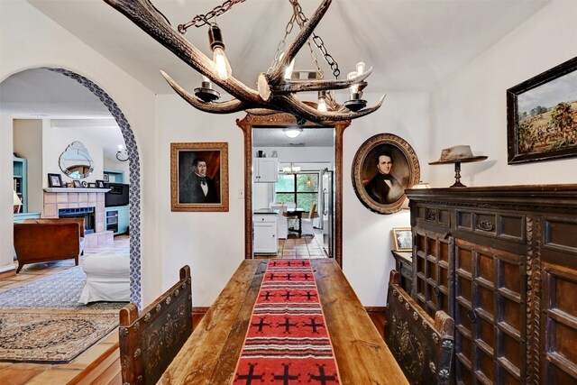 hallway with an inviting chandelier and hardwood / wood-style floors