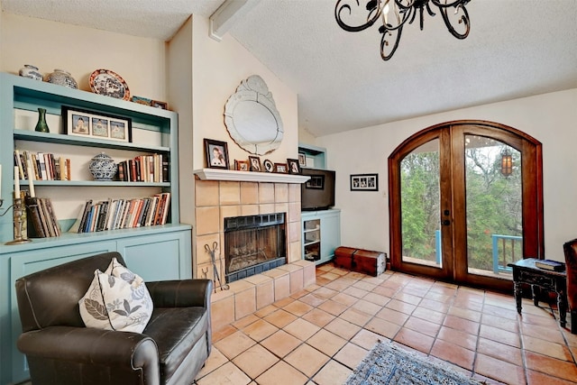 living area featuring vaulted ceiling with beams, a textured ceiling, french doors, a fireplace, and light tile patterned flooring