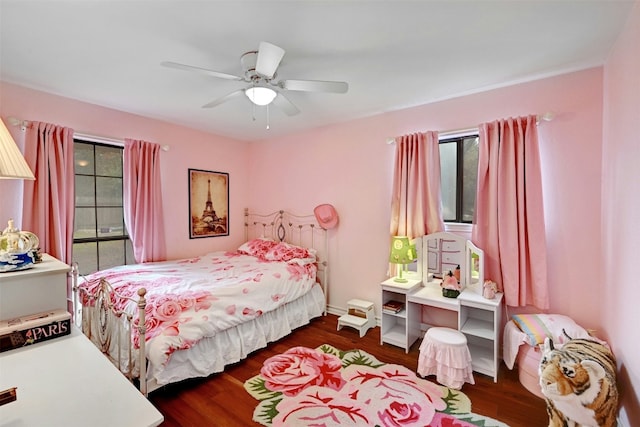 bedroom with dark hardwood / wood-style flooring and ceiling fan