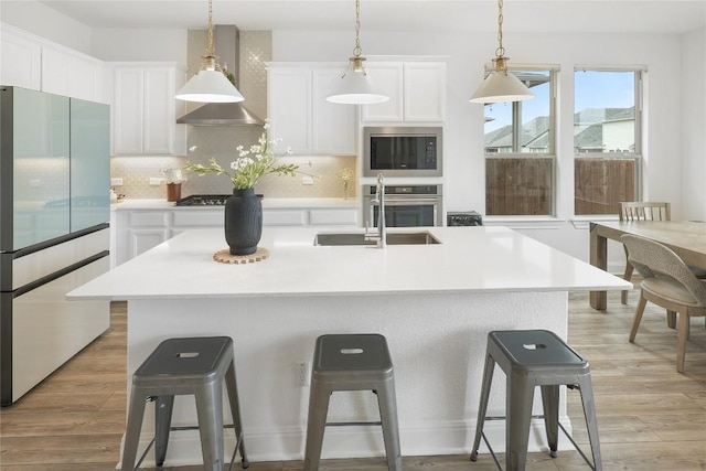 kitchen with stainless steel appliances, an island with sink, and a breakfast bar area