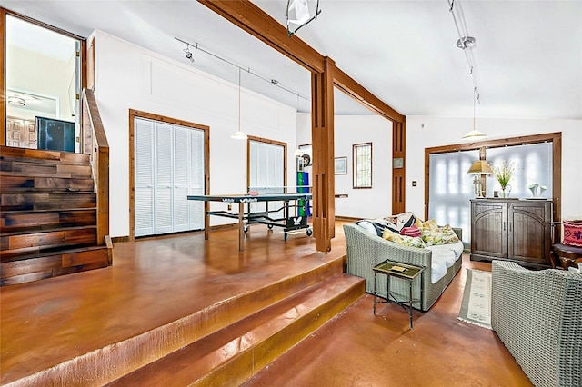 interior space with vaulted ceiling with beams and concrete flooring