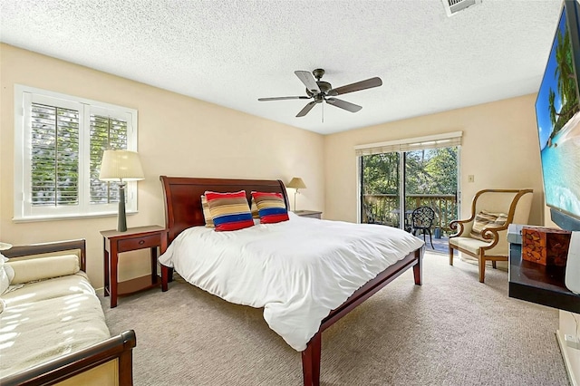 carpeted bedroom with a textured ceiling, access to outside, and ceiling fan