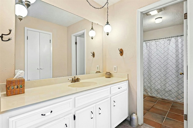 bathroom featuring vanity, a textured ceiling, and walk in shower