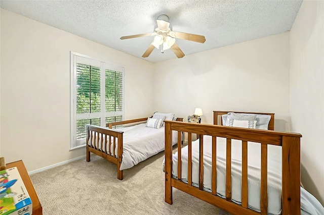 carpeted bedroom with ceiling fan and a textured ceiling