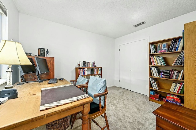 carpeted office with a textured ceiling