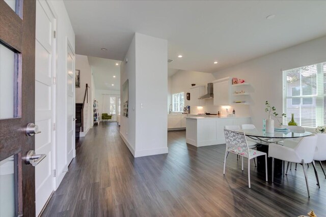 dining room with dark wood-type flooring and vaulted ceiling