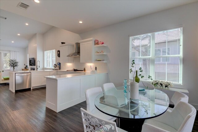 dining area featuring lofted ceiling, dark hardwood / wood-style flooring, and sink