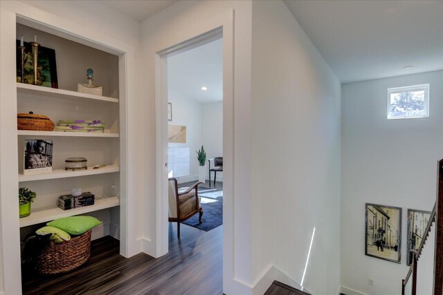 corridor featuring built in shelves and dark wood-type flooring