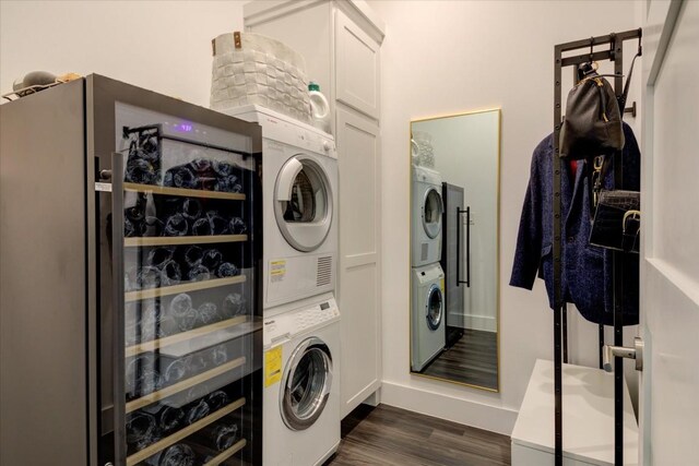 laundry area with stacked washer and dryer, dark hardwood / wood-style floors, and cabinets