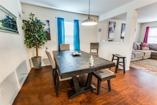 dining area featuring dark wood-type flooring and plenty of natural light