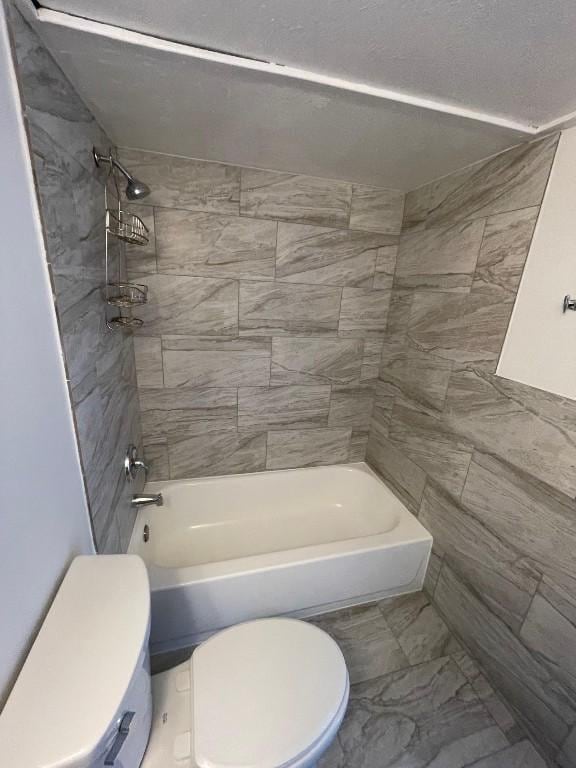 bathroom with tiled shower / bath and toilet