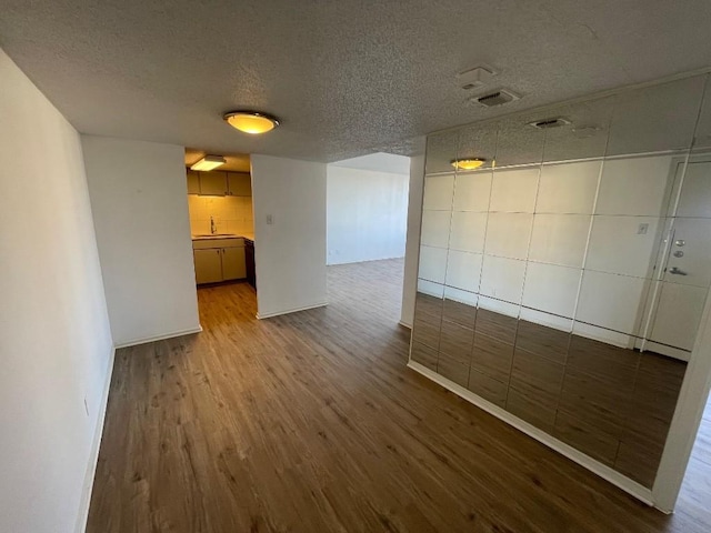 spare room with sink, hardwood / wood-style floors, and a textured ceiling