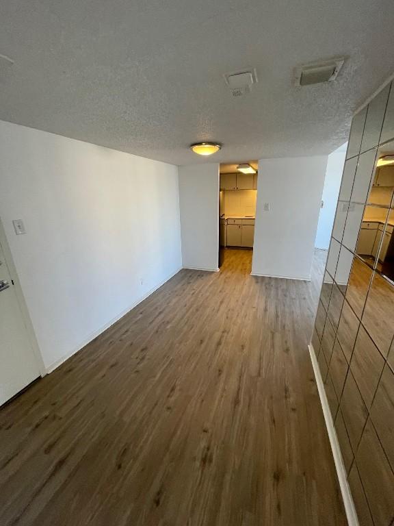 interior space featuring hardwood / wood-style flooring and a textured ceiling