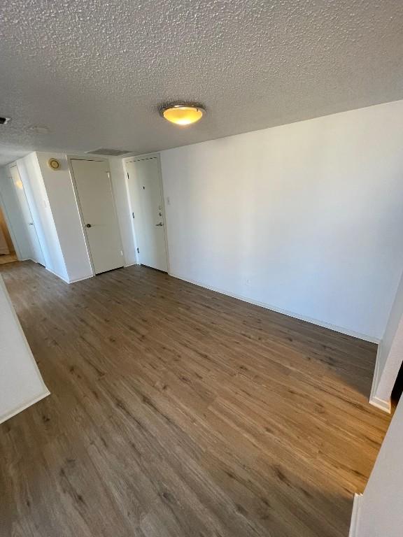 spare room with dark hardwood / wood-style flooring and a textured ceiling