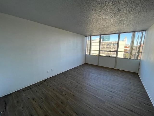 spare room with dark hardwood / wood-style flooring and a textured ceiling