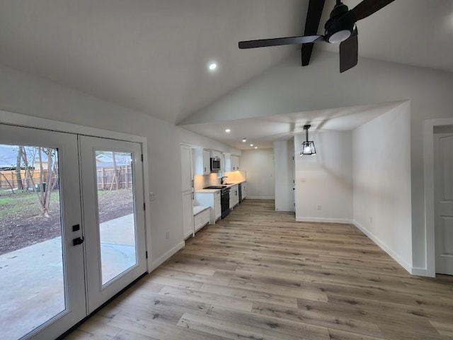 interior space featuring vaulted ceiling with beams, light hardwood / wood-style flooring, french doors, and ceiling fan