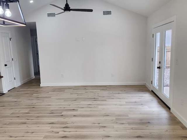 empty room featuring ceiling fan, lofted ceiling, light wood-type flooring, and french doors