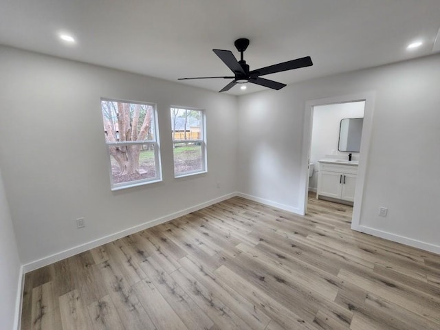 unfurnished bedroom featuring sink, ensuite bath, ceiling fan, and light wood-type flooring