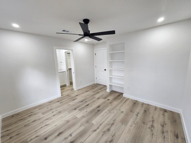 unfurnished bedroom featuring ceiling fan, ensuite bath, light hardwood / wood-style floors, and a closet