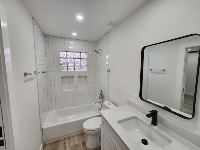 full bathroom featuring vanity, wood-type flooring, toilet, and tiled shower / bath