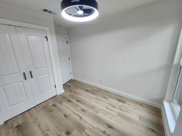 unfurnished bedroom featuring light hardwood / wood-style floors and a closet