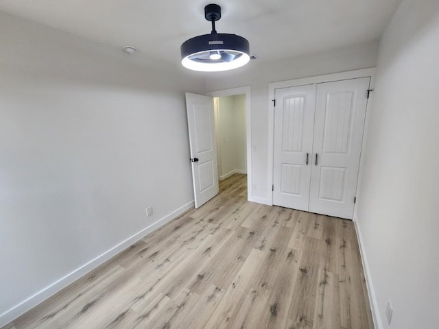 unfurnished bedroom featuring a closet and light wood-type flooring