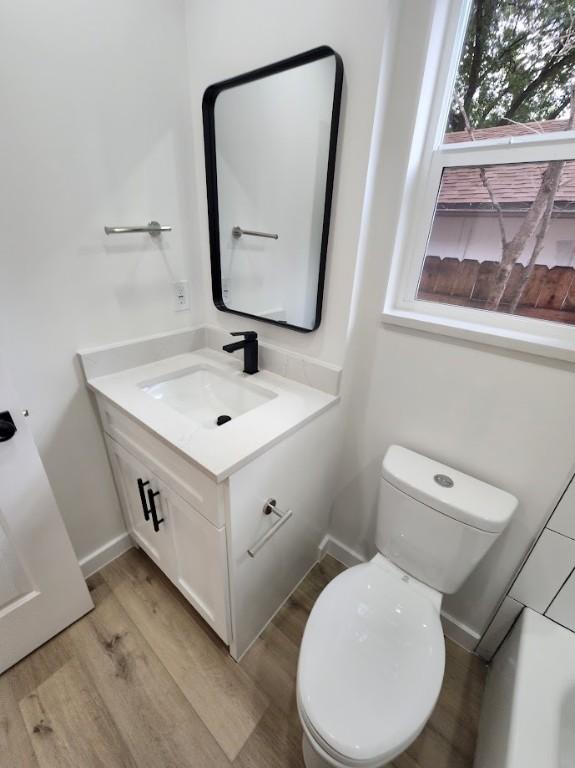 bathroom with vanity, hardwood / wood-style floors, and toilet