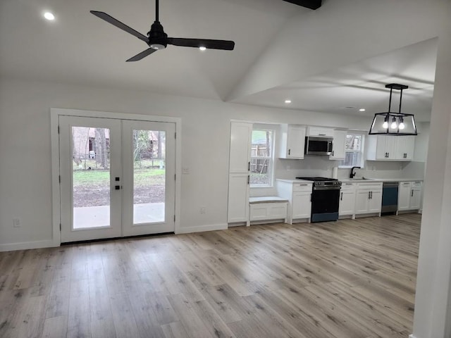 kitchen featuring sink, white cabinetry, hanging light fixtures, light hardwood / wood-style flooring, and stainless steel appliances