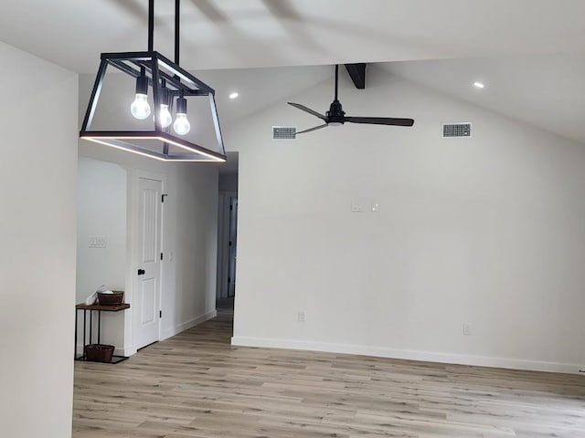 unfurnished room with ceiling fan, lofted ceiling with beams, and light wood-type flooring