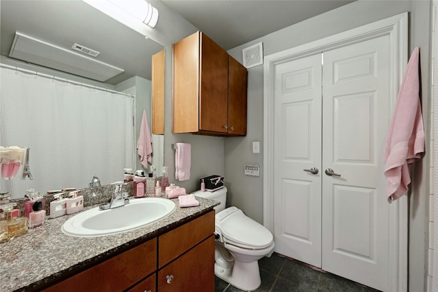 bathroom with tile patterned flooring, vanity, and toilet