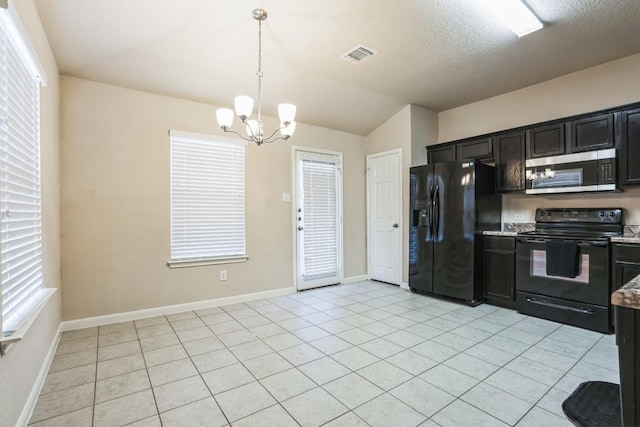 kitchen featuring lofted ceiling, decorative light fixtures, a textured ceiling, light tile patterned floors, and black appliances