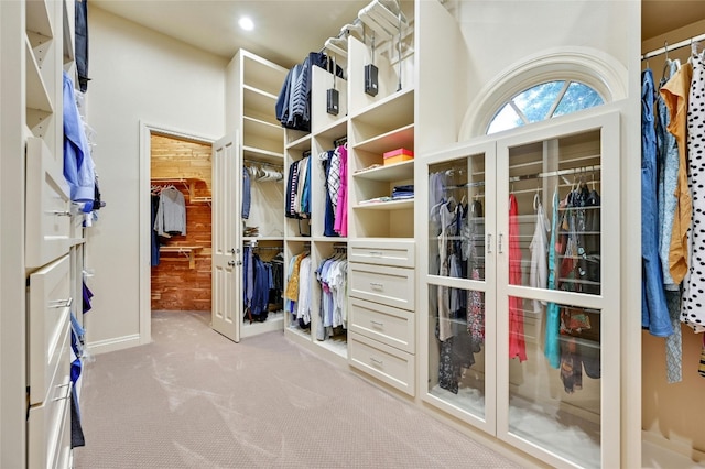 walk in closet with light carpet