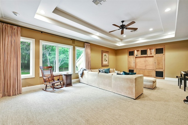 living room with light carpet, ceiling fan, and a tray ceiling