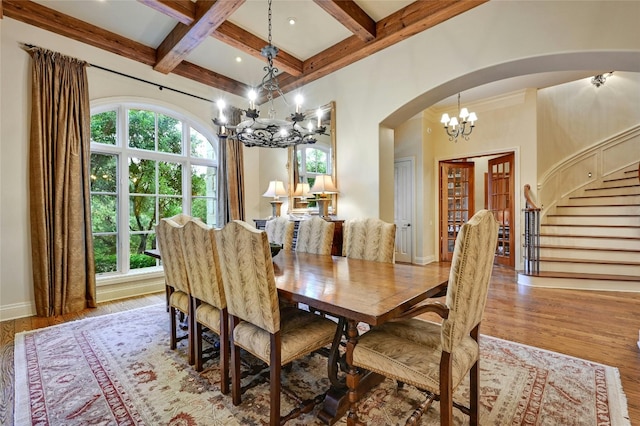 dining area featuring coffered ceiling, a wealth of natural light, beamed ceiling, a chandelier, and light wood-type flooring