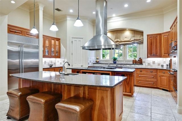 kitchen featuring a kitchen island with sink, sink, appliances with stainless steel finishes, and island exhaust hood