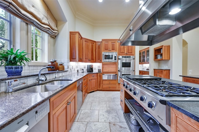 kitchen with sink, dark stone countertops, stainless steel appliances, crown molding, and wall chimney range hood