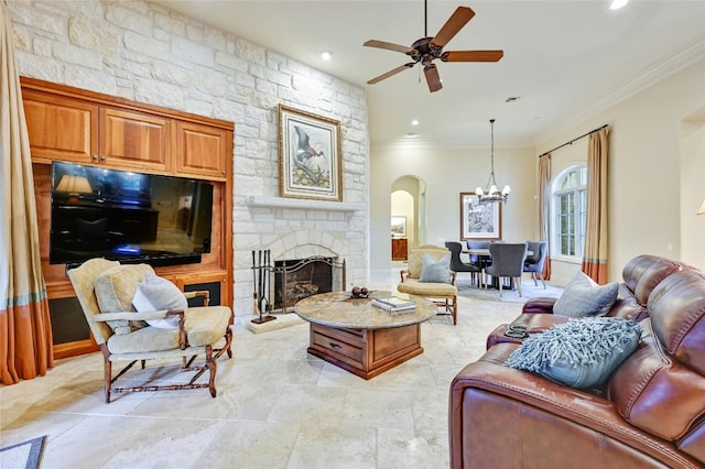 living room with crown molding, a stone fireplace, and ceiling fan with notable chandelier