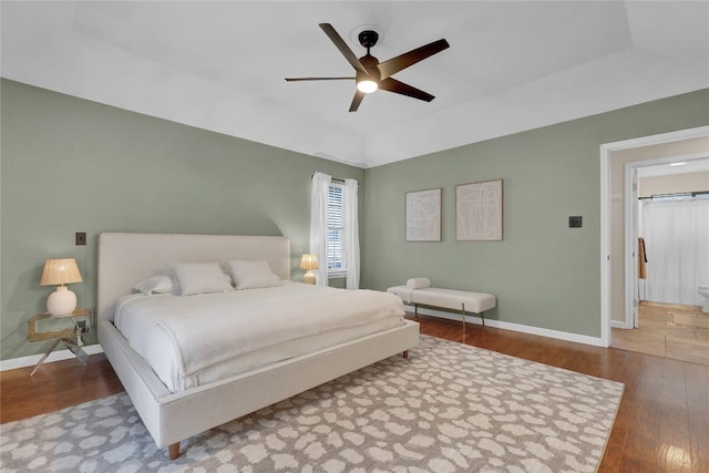 bedroom featuring hardwood / wood-style flooring, a raised ceiling, and ceiling fan