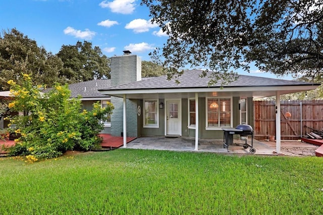 back of house with a yard and a patio