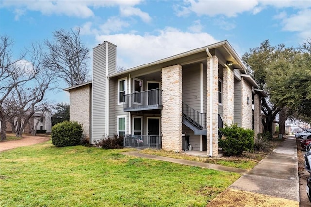 exterior space with a lawn, a chimney, and a balcony