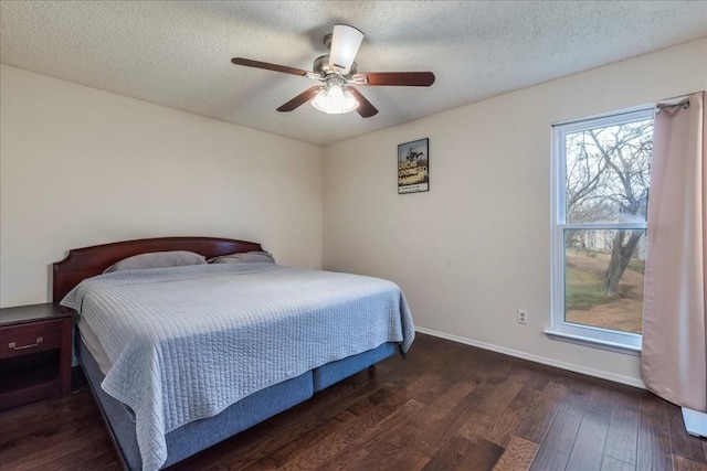 bedroom with a textured ceiling, ceiling fan, dark wood finished floors, and baseboards