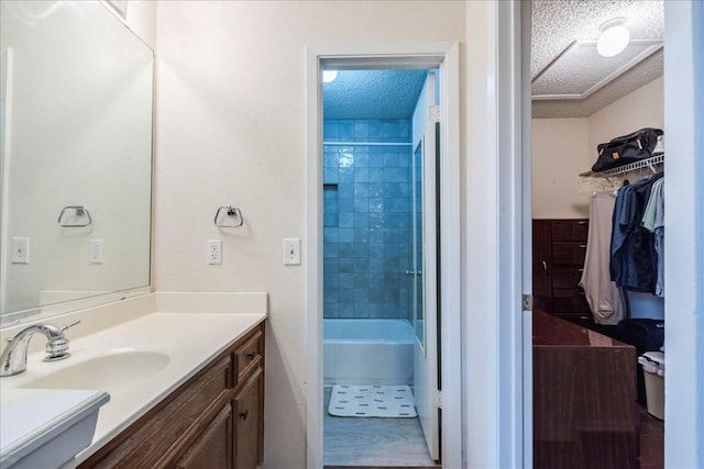 full bath with a textured ceiling, a spacious closet, shower / washtub combination, and vanity