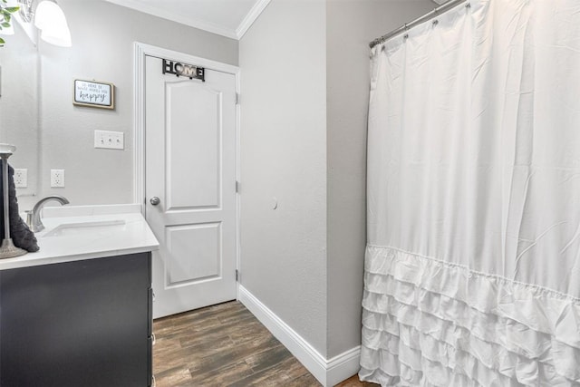 bathroom featuring ornamental molding, wood-type flooring, and vanity