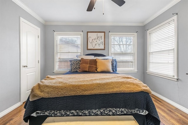 bedroom with crown molding, wood-type flooring, and ceiling fan