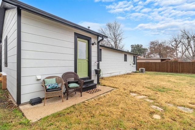 rear view of house featuring central AC and a lawn