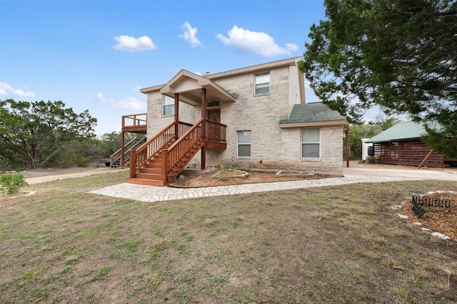 15101 Foy Dr, Austin, TX 78734 - view of front of home featuring stone siding, stairs, a deck, and a front yard