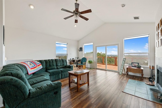 living room with dark wood-type flooring, ceiling fan, and high vaulted ceiling