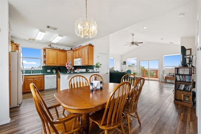 dining area featuring ceiling fan with notable chandelier, high vaulted ceiling, dark hardwood / wood-style flooring, and sink