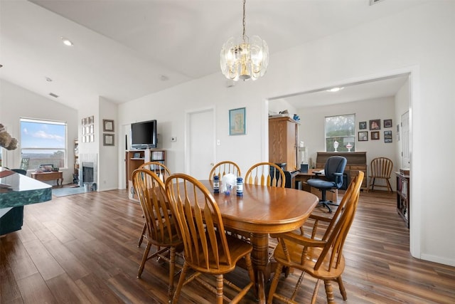 dining room featuring a fireplace, a healthy amount of sunlight, and dark hardwood / wood-style floors