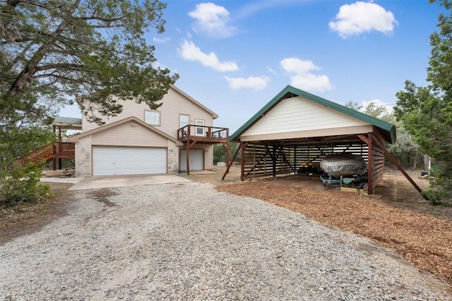 exterior space with a carport, a wooden deck, and a garage